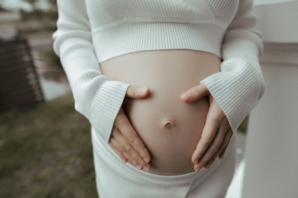 Une femme enceinte portant un collier bola sur sa poitrine Une femme enceinte portant un collier bola sur sa poitrine