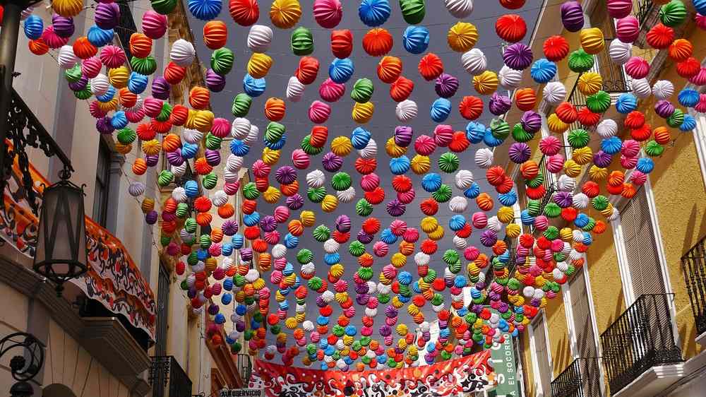 Suspendus, des lanternes colorées remplissent l'espace entre les façades